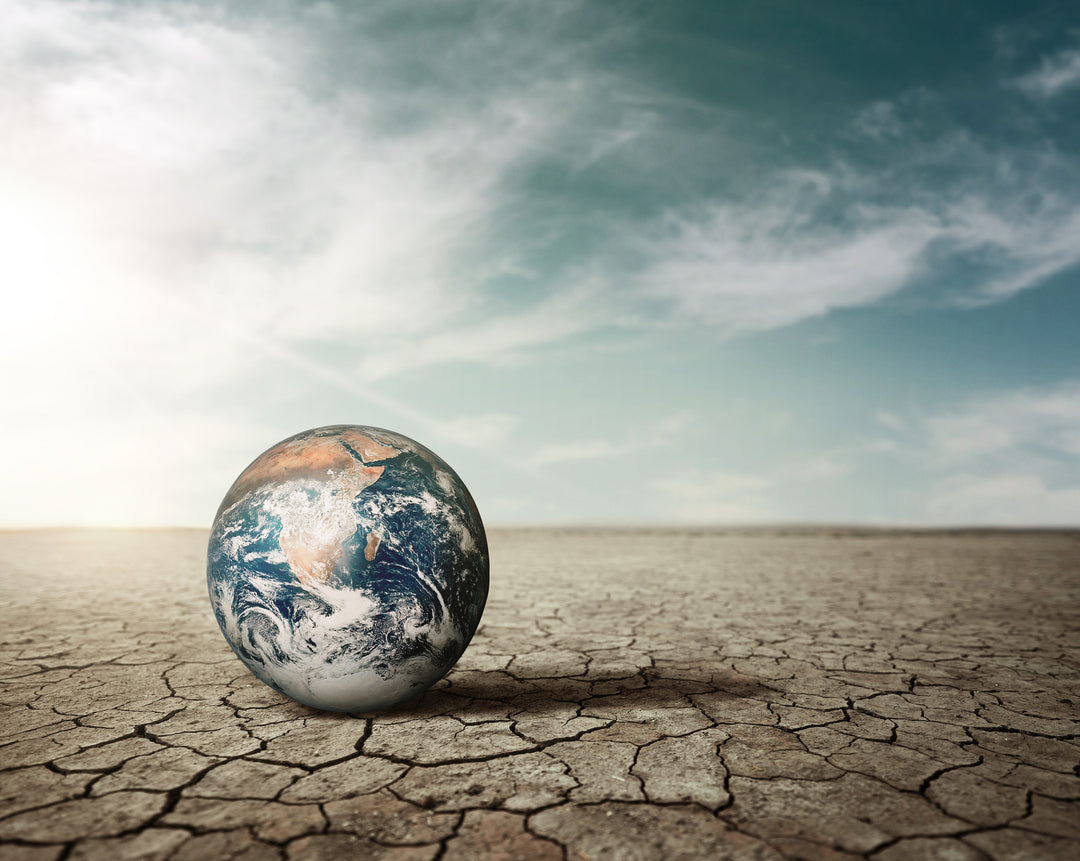 Image by Freepik-climate change on dry soil. Image of Earth on top of dry soil